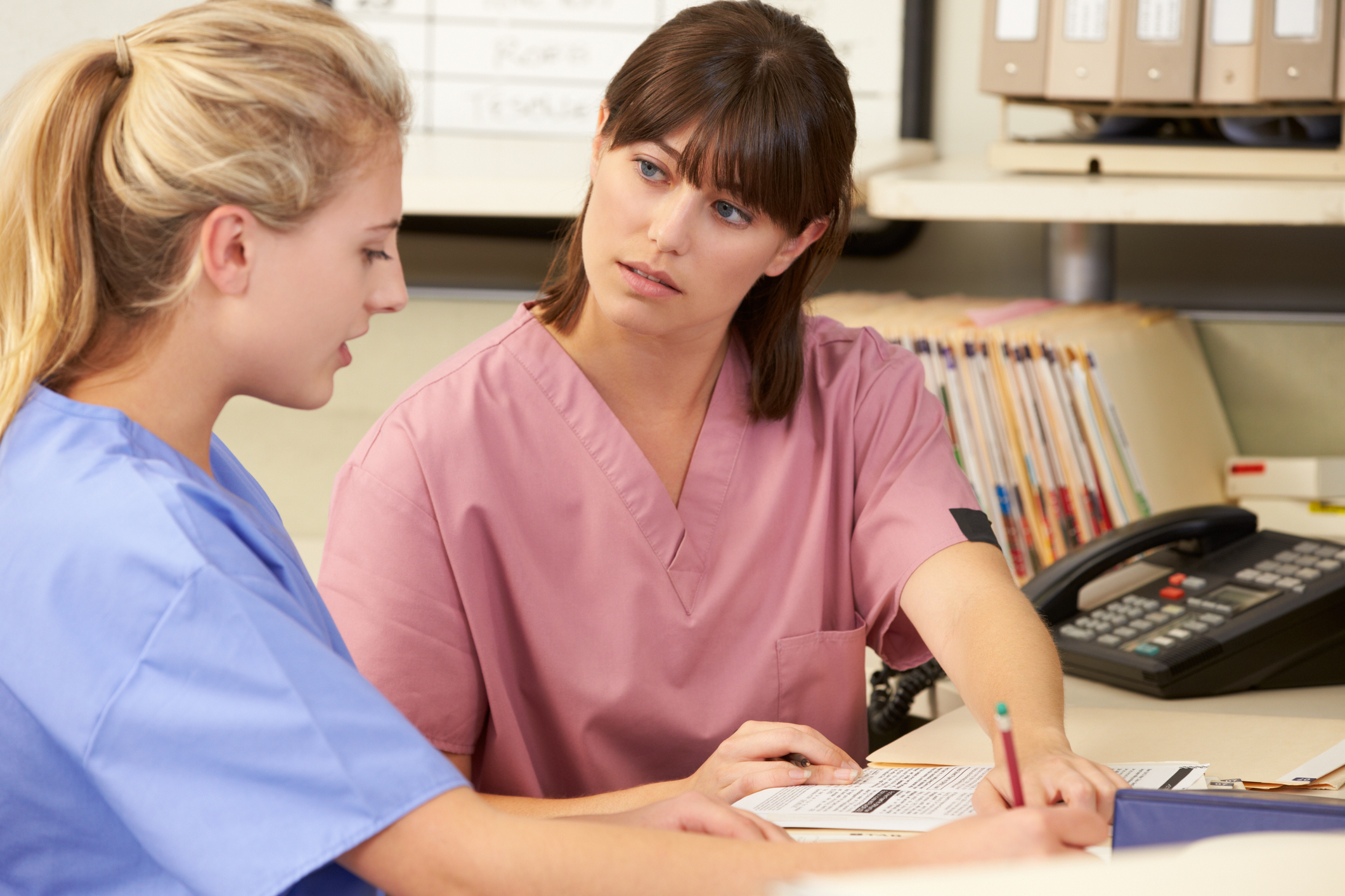 Physician reviewing standards with a newly hired nurse Physician reviewing standards with a newly hired nurse