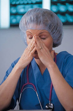 Stressed nurse with hands on her face Stressed nurse with hands on her face