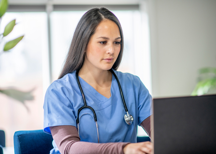 Nurse typing on a laptop Nurse typing on a laptop